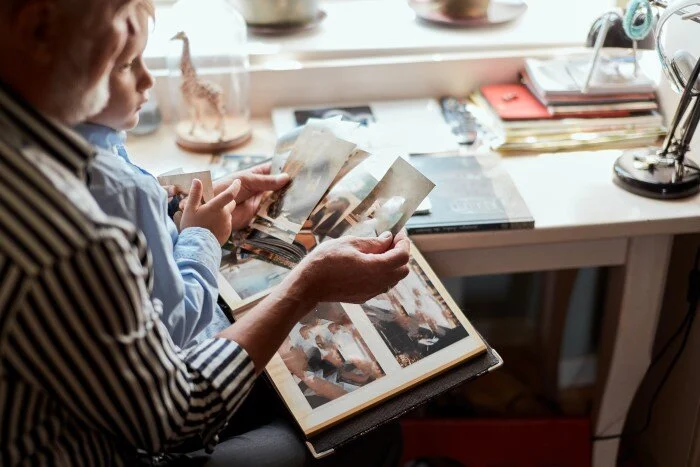 Senior man with grandson organizes memory book