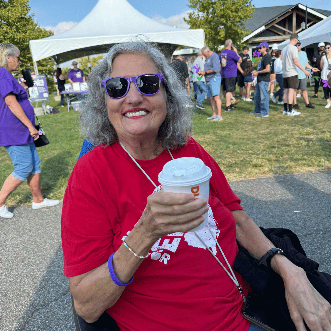 It was a beautiful day to wear purple in celebration of the fight to end Alzheimer's, as a woman shows off her purple sunglasses.