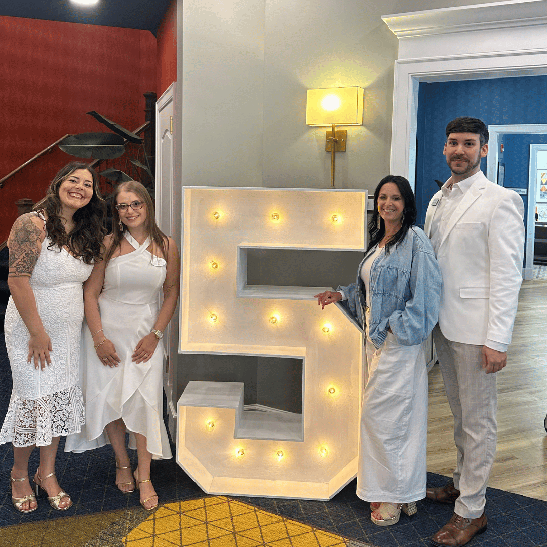 Team members at The Bristal at Somerset pose with a Five celebrating Five Years