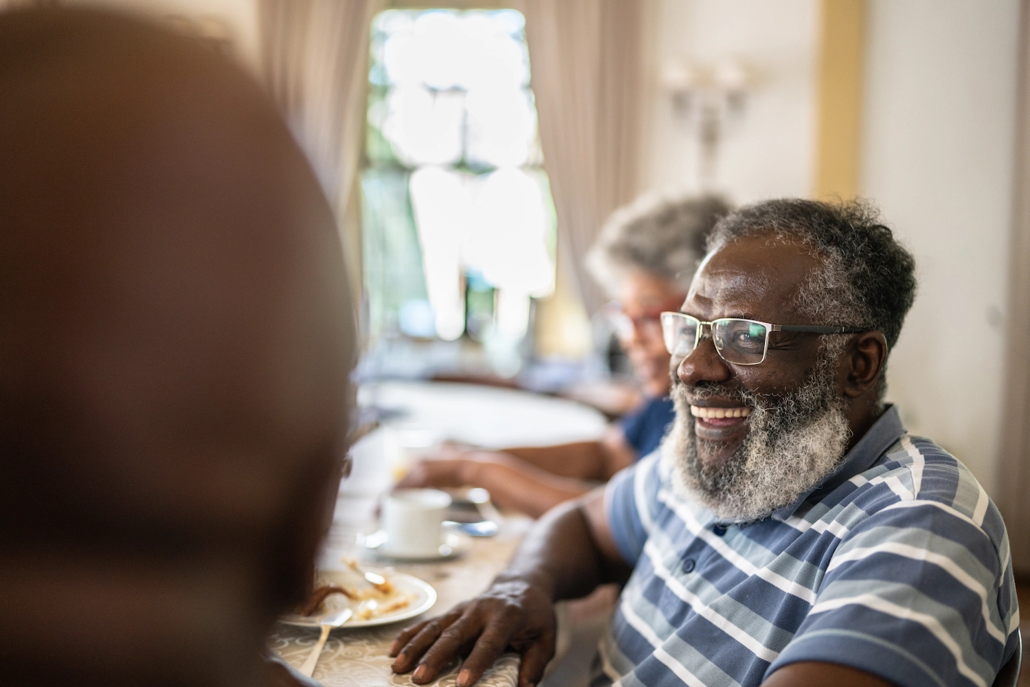The Bristal Assisted Living - Resident smiles while sitting at a table